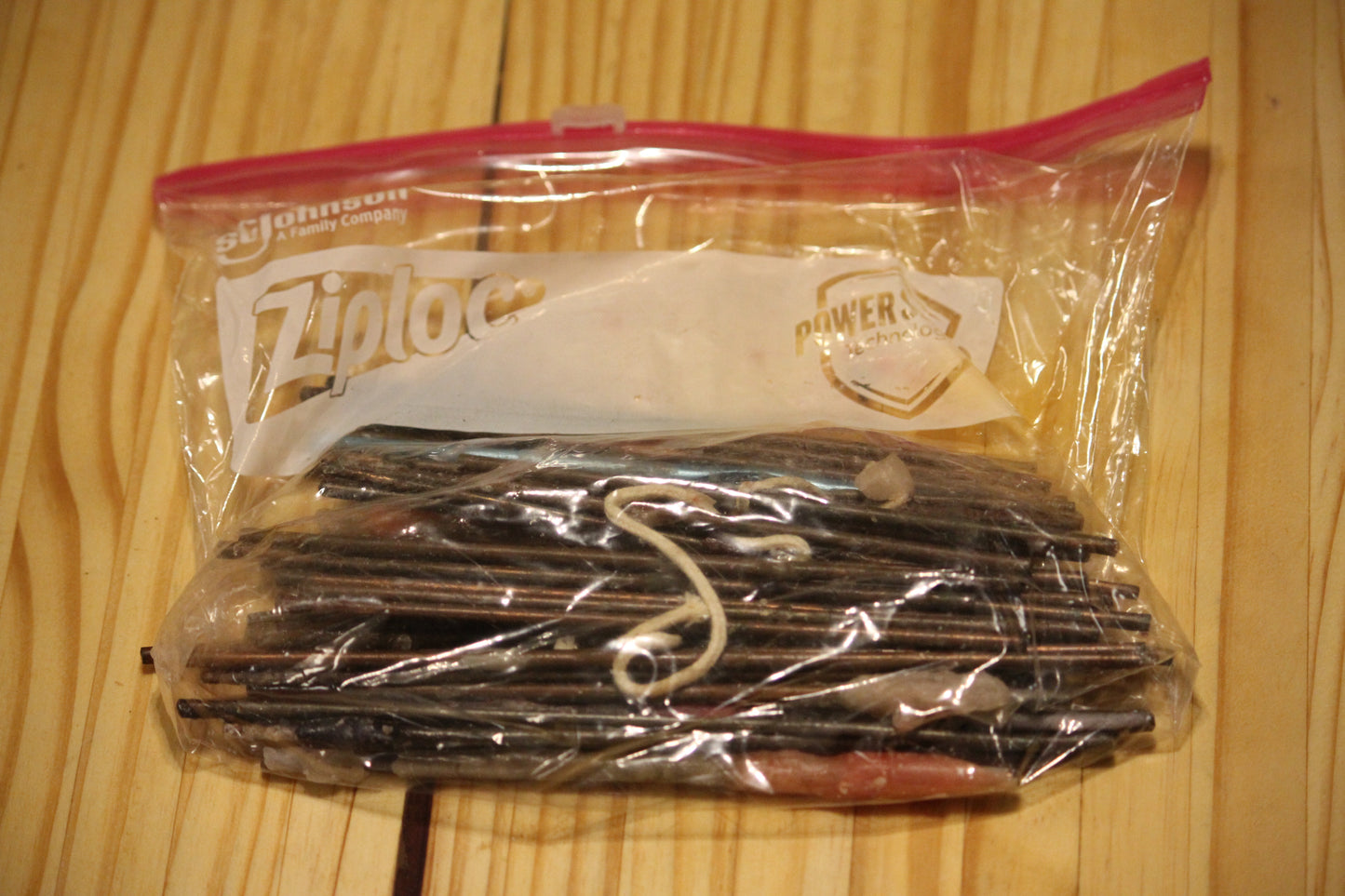 A clear plastic zip-top bag containing metal wick pins.
