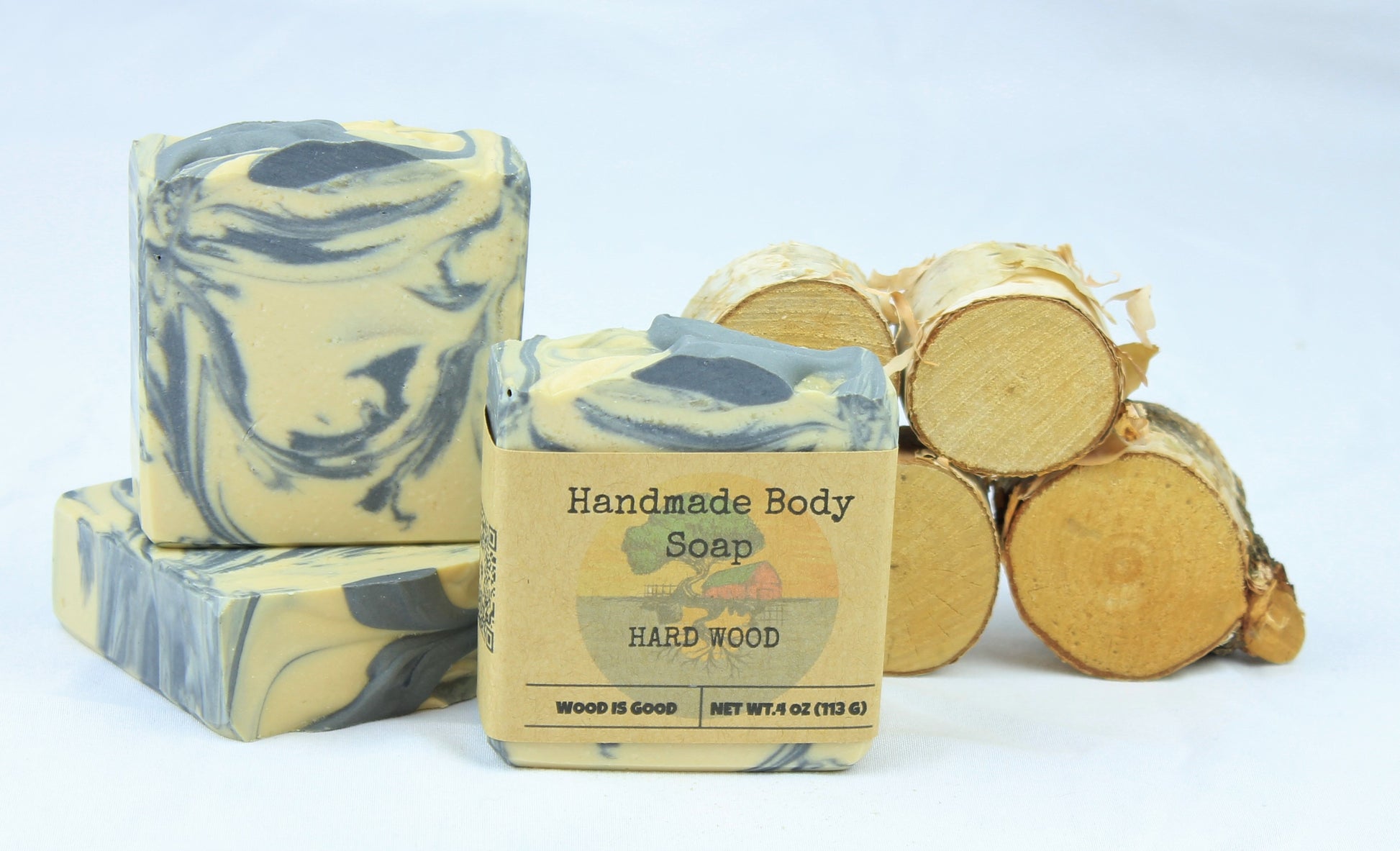 Three bars of Hard Wood bar soap, shown in front of small pieces of cut wood.