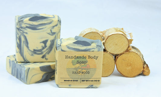 Three bars of Hard Wood bar soap, shown in front of small pieces of cut wood.
