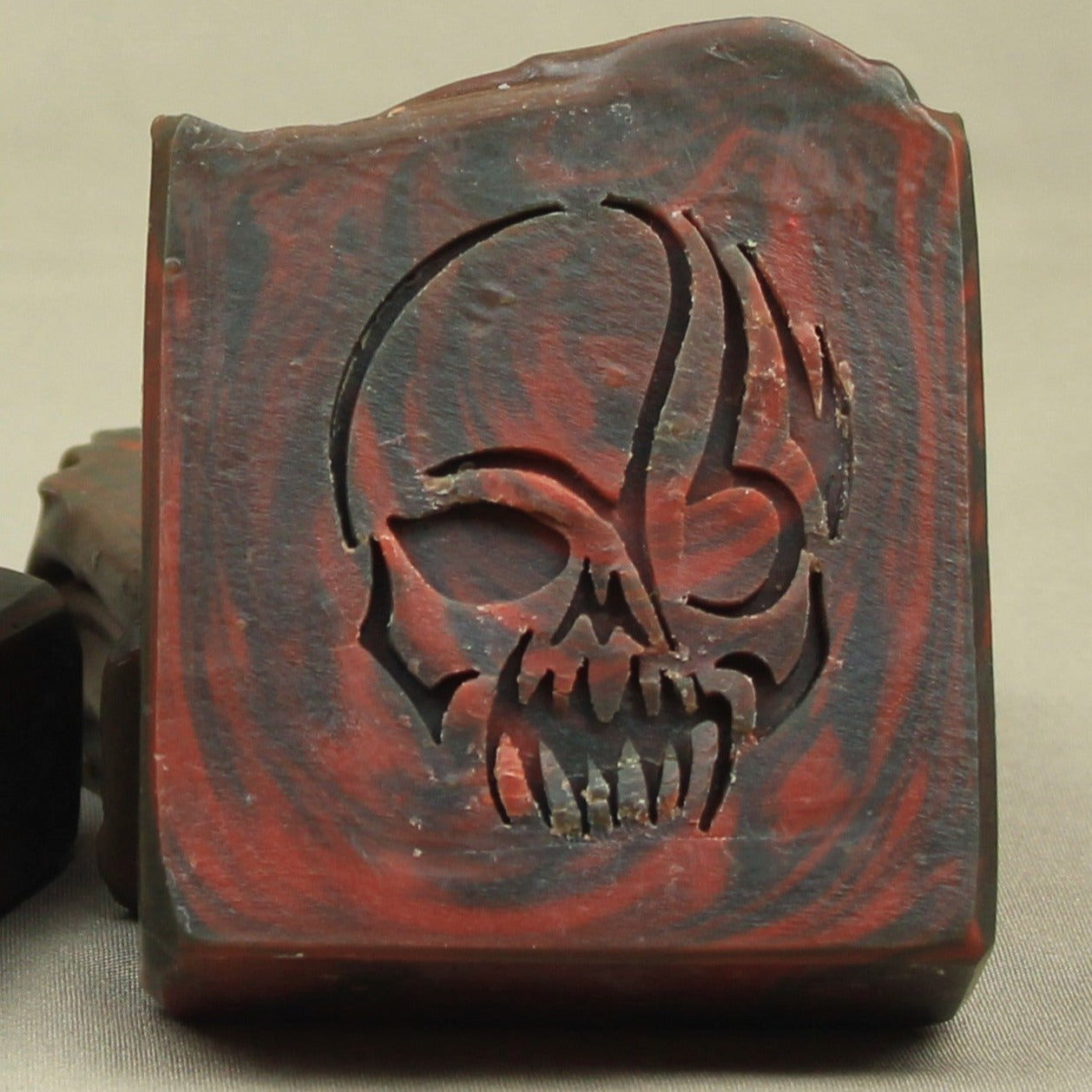 Wrath handmade soap, black and red swirls, skull stamp.  Scented in dragon's blood and bonfire.