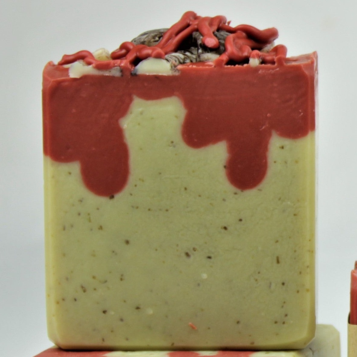One unlabeled 4.5oz bar of Breakfast at Jeff's. Bar has ground oatmeal in the main portion, and is topped with red soap that resembles dripping blood