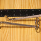 Candle wick trimmers, silver, placed on a light wood surface next to a black measuring ruler for scale.