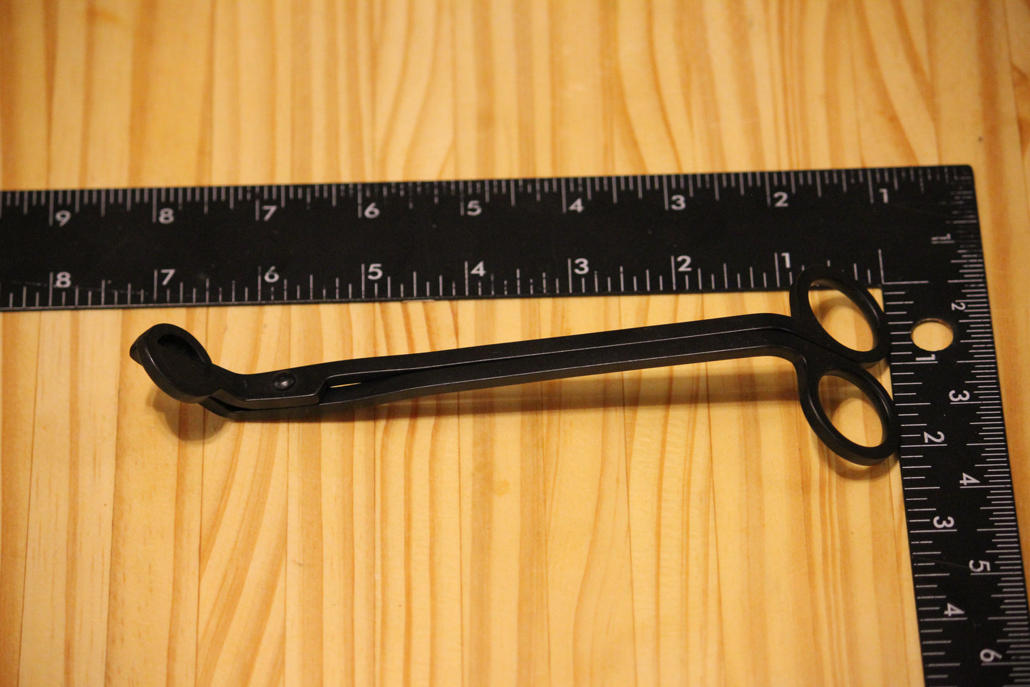 Candle wick trimmers, black, with a black ruler visible along the top and right edges for scale.