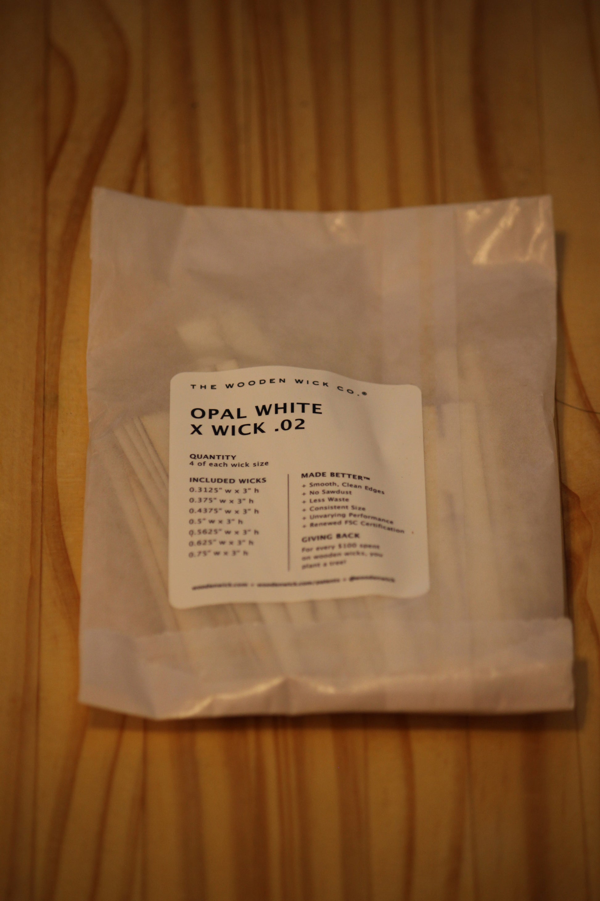 A small clear plastic bag containing white wick material, with a white label reading 'OPAL WHITE X WICK .02' and 'THE WOODEN WICK CO.