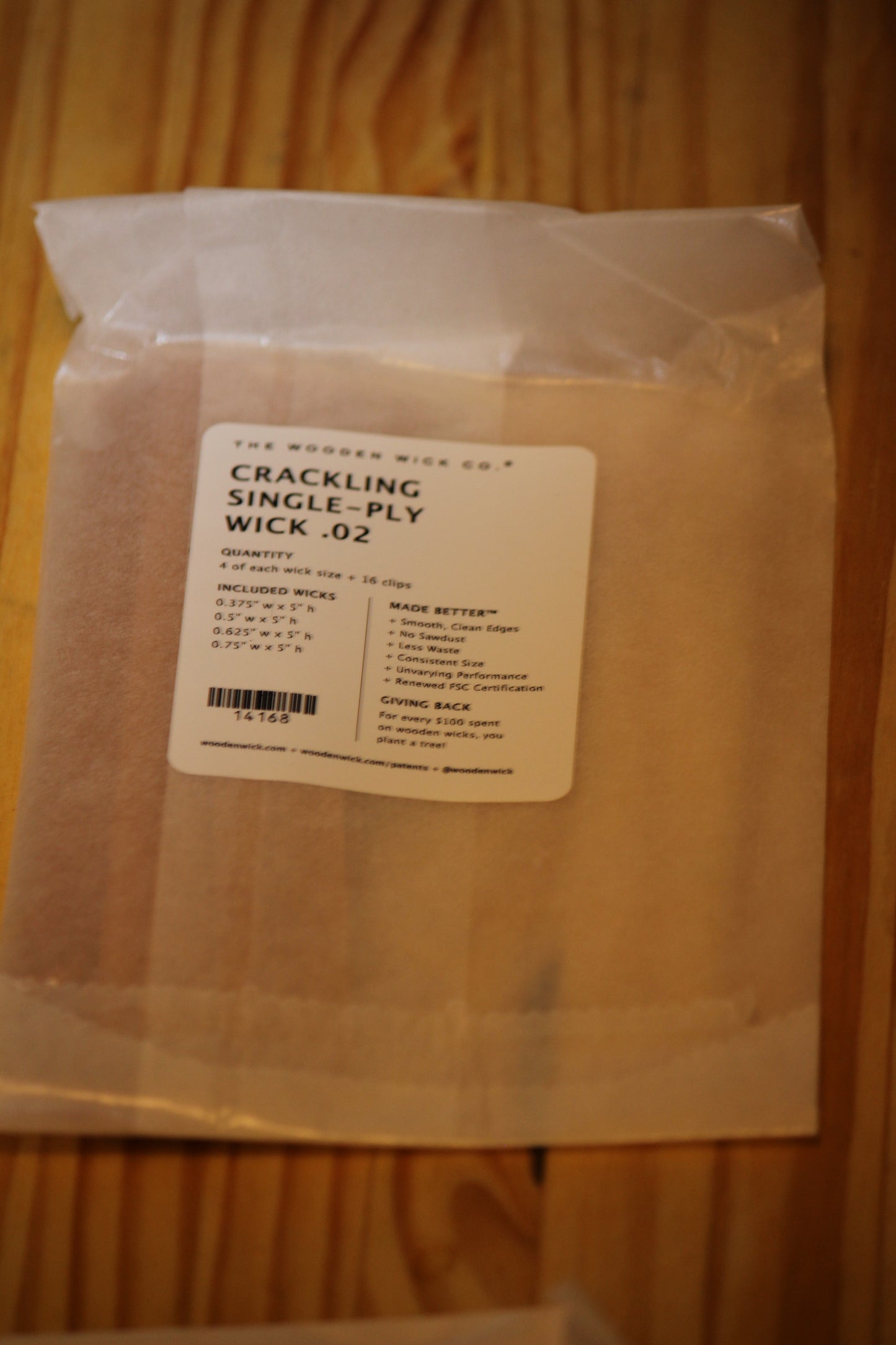 A clear plastic bag containing crackling single ply wood wicks, with a white label showing the brand 'The Wooden Wick Co.