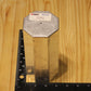 A metal octagon pillar mold, shown on a light wood grain background with a black ruler for scale.