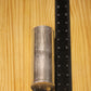 A cylindrical metal pillar mold, shown next to black rulers on a light wood grain background to indicate its dimensions.