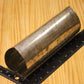 A metal heart shaped pillar mold, shown on a light wood grain background with a black ruler for scale.