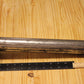 A metal cylindrical pillar mold, shown on a light wood grain background with a black ruler for scale.