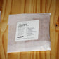 A clear plastic bag containing wood wicks with a white label reading 'THE WOODEN WICK CO. NATURAL X WICK .
