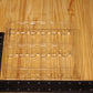 A clear plastic tray with multiple vertical compartments, shown on a light wood grain surface with a black ruler for scale.