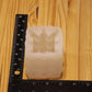A translucent white silicone mold with a detailed skull design, shown next to a black ruler on a light wood grain background to indicate its size.