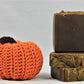 Stack of 3 deep brown soaps with gold embossed tops. Scented in pumpkin spice and pictured next to a crotched pumpkins made by Lauren at www evandroz.com