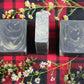 black with yellow swirls soap bars on a red and black plaid background, encircled by chamomile flowers