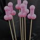 A bouquet of six pink soap penises against a black backdrop. 