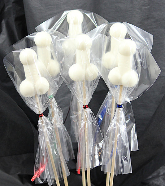 A bouquet of six white soap penises, individually wrapped in clear cellophane, against a black backdrop. 