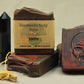 Wrath handmade soap, black and red swirls, skull stamp. Scented in dragon's blood and bonfire.  Pictured with onyx tower and bones
