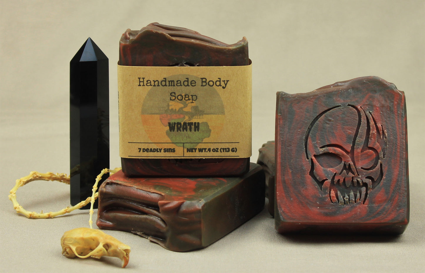 Wrath handmade soap, black and red swirls, skull stamp. Scented in dragon's blood and bonfire.  Pictured with onyx tower and bones
